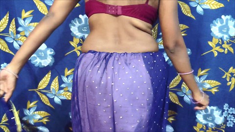 Une femme au foyer indienne sensuelle en sari bleu danse avec passion