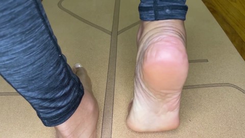 La belleza ébano practica yoga y estiramientos de dedos con un toque de fetiche por los pies