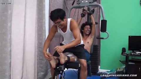 Jeune asiatique taquiné par son entraîneur de gym lors d'une séance d'entraînement intense