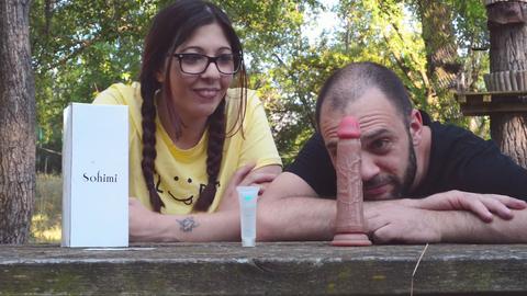 Joven YouTuber italiana con grandes pechos revisa un juguete en el parque detrás de escena